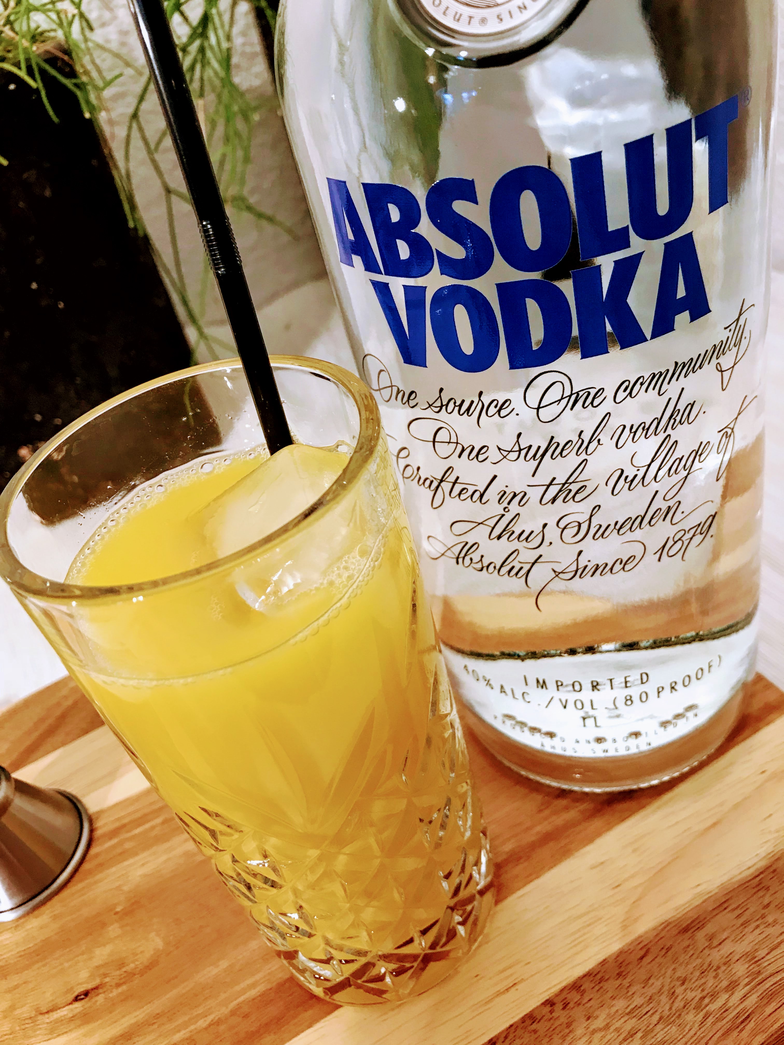 Afbeelding van een glas screwdriver cocktail en een fles wodka